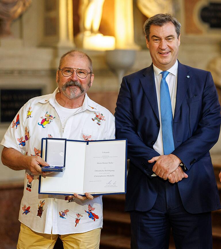 Lebensretter Rainer Sieke mit Ministerpräsident Markus Söder bei der Verleihung der Christophorus-Medaille am 3. Mai 2024 in München. Lebensretter Rainer Sieke mit Ministerpräsident Markus Söder bei der Verleihung der Christophorus-Medaille am 3. Mai 2024 in München.