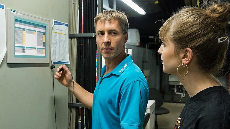 Andreas Böhm erklärt Lena Köster am zentralen Touch-Monitor im Keller die Technik des Schwimmbads.