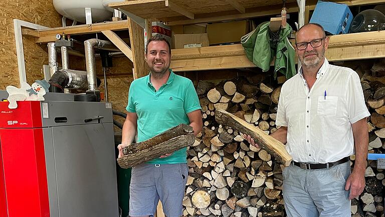 Sohn Simon und Vater Martin Schmitt aus Salz bei Bad Neustadt heizen ihre beiden nebeneinander gelegenen Häuser über ein Heizsystem mit Scheitholzkessel.