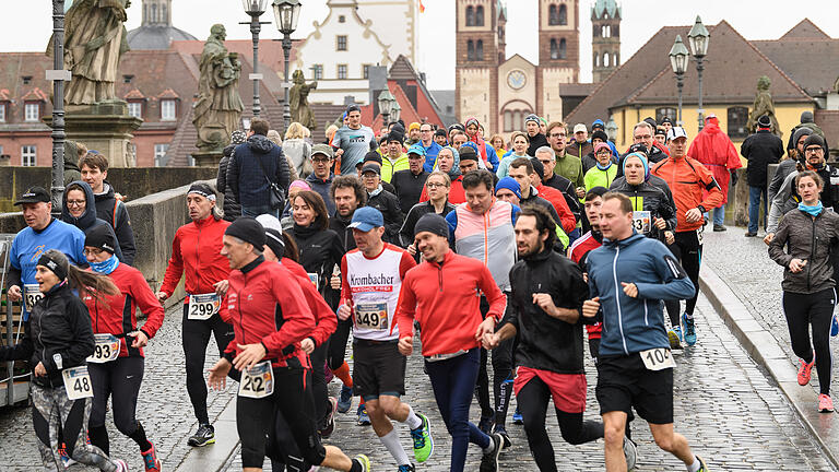 Daniel Peter       -  Zahlreiche Menschen überqueren am Samstag (16.03.19) im Rahmen des Gedächtnislaufs die Alte Mainbrücke in Würzburg. Mit dem Event wollen die Veranstalter an die Bombardierung der Domstadt am 16.03.1945 erinnern.