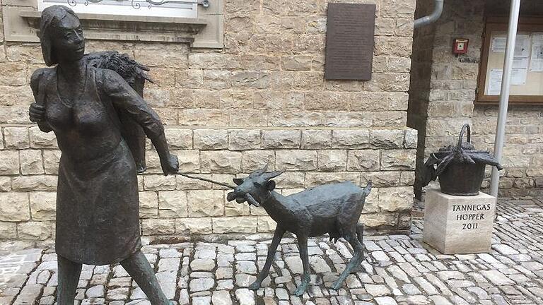 Vor dem Rathaus in Albertshofen zieht ein Frau mit ihrer Ziege ihre Runden. Sie gehört zum Ortsbild dazu. FOTO: Siegfried Sebelka