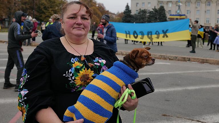 Nastya mit ihrem Hund Ritschi in einem patriotischen Hundepulli: Nastya hatte am Tag der russischen Invasion angefangen, den Pulli in den ukrainischen Farben zu stricken.