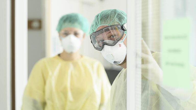 Dr. Matthias Held, Ärztlicher Direktor am Klinikum Würzburg Mitte, steht zusammen mit einer Pflegerin am Eingang der Isolierstation für Corona-Patienten in der Missioklinik.