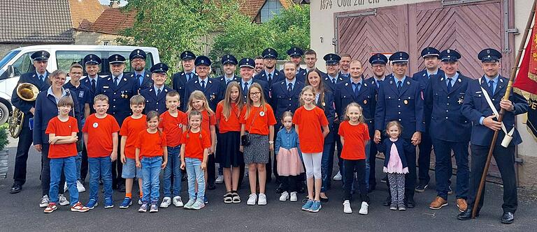 Eine starke und sehr stolze Truppe – die Kirchschönbacher Wehr im Jubiläumsjahr 2024 mit all ihren Gruppen. Kinderfeuerwehr, aktive Wehr, Vorstandschaft und Ehrenmitgliedern haben sich zum Erinnerungsfoto an ihr großes Fest und Jubiläum vor ihrem Feuerwehrhaus in der Ortsmitte aufgestellt.