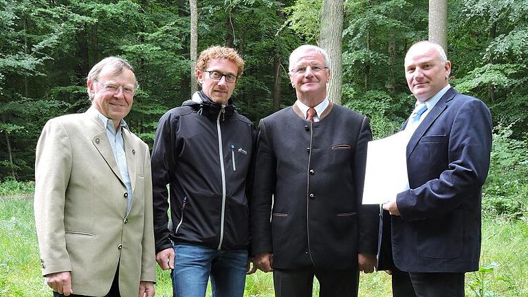 Neue Grenze: Vermessungskreisamtsrat Thomas Baumann (rechts) übergibt Bürgermeistern Marcus Wessels (2. von links) und Edwin Gramlich (2. von rechts) die Urkunde, gemeinsam mit Bertold Dissinger, dem Vorsitzenden der Teilnehmergemeinschaft der Flurneuordnung Wittighausen-Vilchband (links).