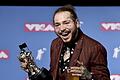 Ein Bierchen und ein Astronaut für Post Malone. Foto: an Agostini/Invision/AP       -  US-Rapper Post Malone zeigt gerne, was er hat. Mit seinem 'Diamanten-Lächeln' präsentiert er die Trophäe, die er bei den MTV Video Music Awards 2018 abräumte.