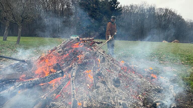 Das Bild zeigt Manuel Rüppel beim Verschließen des Feuers nach Einlegen des Lakefleisches in die Glut.