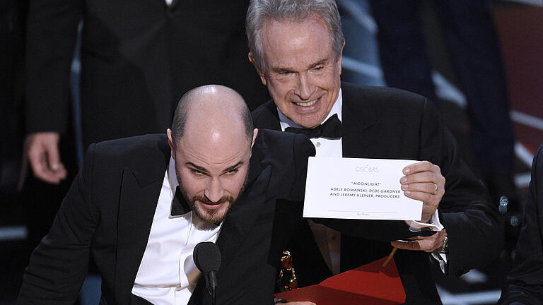 Nach Oscar-Patzer: Mitarbeiter erhalten Show-Verb       -  ARCHIV - Nach einer versehentlich falschen Bekanntgabe des besten Films zeigt Jordan Horowitz (l), Produzent des Films «La La Land», am 26.02.2017 in Hollywood, Los Angeles, USA, während der Verleihung der Oscars 2017, den 89. Academy Awards, den Umschlag mit dem wirklichen Gewinner des Awards für den besten Film «Moonlight». Rechts neben ihm steht Warren Beatty. Die Umschlags-Panne bei der Oscar-Gala hat für die verantwortlichen Mitarbeiter Folgen. Die beiden Angestellten der Prüfgesellschaft PricewaterhouseCoopers (PwC), die auf der Oscar-Bühne die Umschläge mit dem Gewinnernamen austeilten, werden bei zukünftigen Shows nicht mehr dabei sein. (zu dpa «Nach Oscar-Patzer: Verantwortliche Mitarbeiter erhalten Show-Verbot» vom 02.03.2017) Foto: Chris Pizzello/Invision/AP/dpa +++(c) dpa - Bildfunk+++