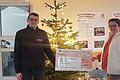 Stefanie Kimmel (rechts im Bild), Leiterin des Jugendhilfezentrums Grafenrheinfeld und Andre Hader (links), Auszubildender bei Schäflein und Projektleiter, bei der Übergabe der Weihnachtsgeschenke und des Spendenschecks.