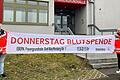 Um auf die neuen Termine für das Blutspenden in Ebern aufmerksam zu machen, wurden neue Transparente angeschafft, die in der jeweiligen Woche an verschiedenen Standorten in Ebern aufgehängt werden. Daniel Brunnhuber (links), stellvertretender Leiter der BRK-Bereitschaft Ebern, und Bereitschaftsmitglied Fabian Weber zeigen eines der Transparente vor dem Eingang zur Frauengrundhalle.