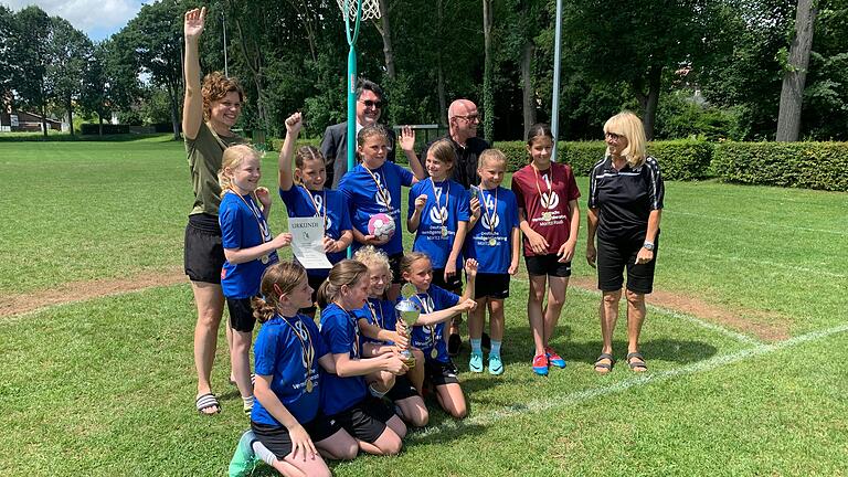 Auf dem Foto die Spielerinnen: Helen Dausacker, Frieda Füller, Sarah Heinrich, Hanna Howorka, Klara Koch, Alina Mauder, Sofia Paone, Merle Pfeuffer, Lotte Weis und Finnja Weiß, sowie die Lehrerin Frau Markert, Herr Kirchner von der Sparkasse Schweinfurt-Haßberge, Herr Schulrat Hagen und Frau Weingart vom Arbeitskreis Schule und Sport.