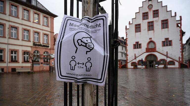 Ein Schild verweist auf die Maskenpflicht in der Innenstadt in Karlstadt.&nbsp;