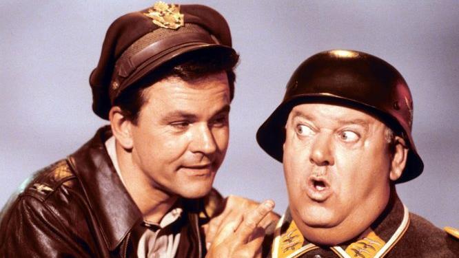 Blödelei im vermeintlichen Kriegsgefangenenlager Hammelburg: Immer wieder wird Sergeant Schultz (John Banner, rechts) unwissend zum Verbündeten von Colonel Hogan (Bob Crane). Foto: Paramount PICTURES       -  Blödelei im vermeintlichen Kriegsgefangenenlager Hammelburg: Immer wieder wird Sergeant Schultz (John Banner, rechts) unwissend zum Verbündeten von Colonel Hogan (Bob Crane). Foto: Paramount PICTURES