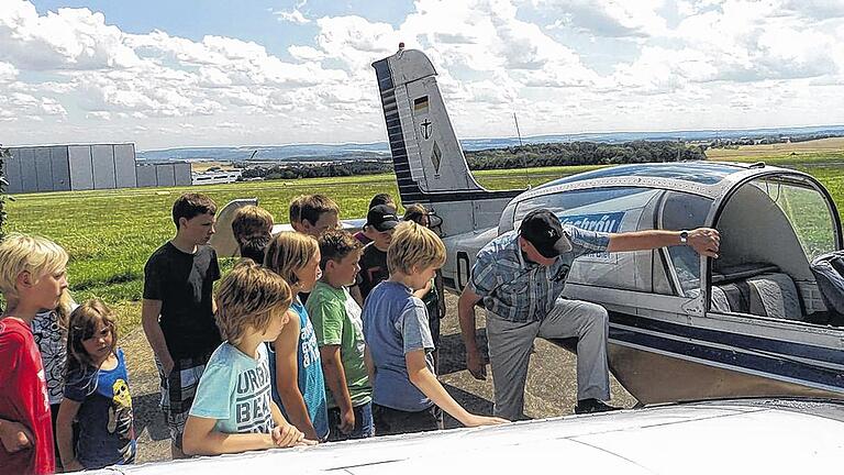 So steigt man ins Flugzeug ein: Dieter Elbert vom Flugsportclub Altfeld zeigt den Ferienprogramm-Kindern, wie es geht.