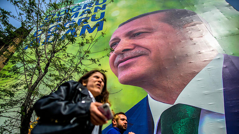 Vor den Wahlen in der Türkei.jpeg       -  Fußgänger gehen an einem Wahlkampfplakat des türkischen Präsidenten Recep Tayyip Erdogan vorbei. Obwohl der Amtsinhaber sich größtenteils willfähriger Medien bedienen kann, liegt er in fast allen Umfragen hinten.