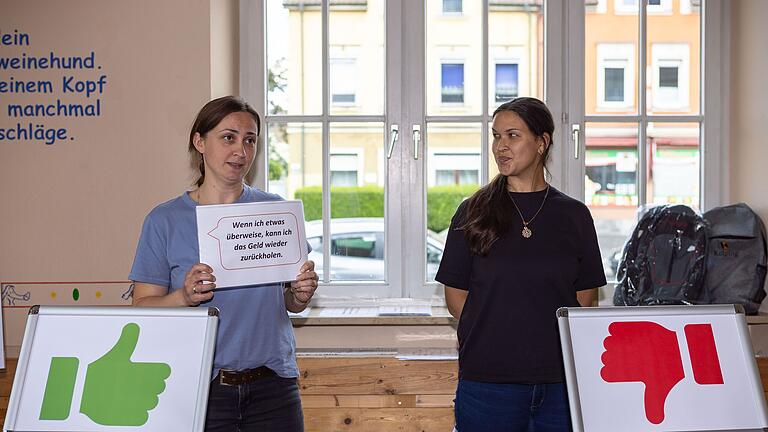 Die Schuldnerberaterinnen Irina Danilischin (links) und Stefanie Mößlein (rechts) erklären den Schülern an der Adolph - Kolping - Schule in Schweinfurt, worauf Menschen beim Bezahlen durch Finanzdienstleistern achten sollten.