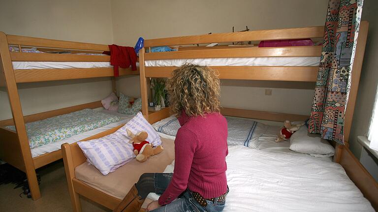 Eine Frau sitzt in dem Zimmer, das sie mit ihren Kindern in einem Frauenhaus bewohnt. Symbolbild: Stephanie Pilick/dpa Foto: Stephanie Pilick Eine Frau sitzt in dem Zimmer, das sie mit ihren Kindern in einem Frauenhaus bewohnt. Symbolbild: Stephanie Pilick/dpa Foto: Stephanie Pilick