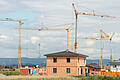 Hausbau       -  ARCHIV - Baukräne stehen am 08.08.2012 in einer Neubausiedlung in Parkstetten (Bayern) hinter dem Rohbau von einem Einfamilienhaus.