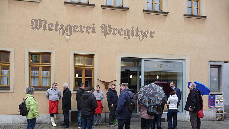 Neueröffnung Metzgerei Eisenhauer - Warten auf die Neueröffnung: Eine Traube von Menschen wartet in der Ochsenfurter Hauptstraße darauf, dass sich nach dreimonatigem Umbau die Tür zur Metzgerei wieder öffnet. Neueröffnung Metzgerei Eisenhauer - Warten auf die Neueröffnung: Eine Traube von Menschen wartet in der Ochsenfurter Hauptstraße darauf, dass sich nach dreimonatigem Umbau die Tür zur Metzgerei wieder öffnet.