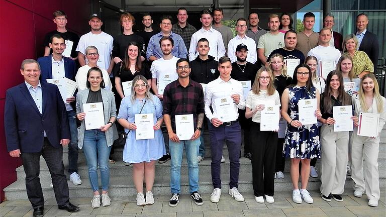 Die Besten der Besten der Sommerprüfung 2023 in der Jakob-Preh-Berufsschule Bad Neustadt. Links vorne Schulleiter Michael Wimmel, hinten rechts Konrektor Christian Stöhr, neben ihm Fördervereins-Vorsitzende Hildegard Steinhardt und vor ihm stellvertretende Landrätin Eva Böhm.