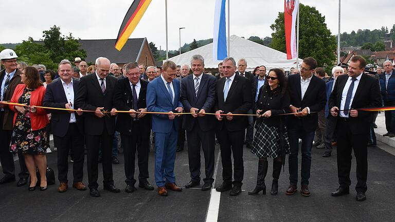 Gemeinsam mit weiteren Ehrengästen durchtrennten Bürgermeister Peter Juks (Sechster von rechts) und Ministerialdirigent Wolfgang Wüst (Fünfter von rechts) das symbolische Band zur Verkehrsfreigabe der Neuen Mainbrücke in Ochsenfurt.