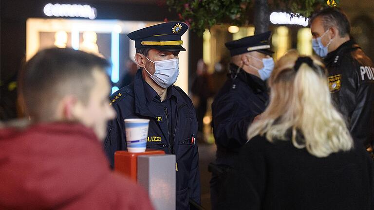 Nicht nur in privaten Wohnungen, auch im öffentlichen Raum müssen Polizeibeamte immer wieder einschreiten, weil gegen die Corona-Regeln verstoßen wird. Das Foto zeigt Einsatzkräfte der Polizei, die am 5. November 2020 am Vierröhrenbrunnen in Würzburg eine unangemeldete Demonstration gegen die Coronamaßnahmen auflösen mussten.&nbsp;