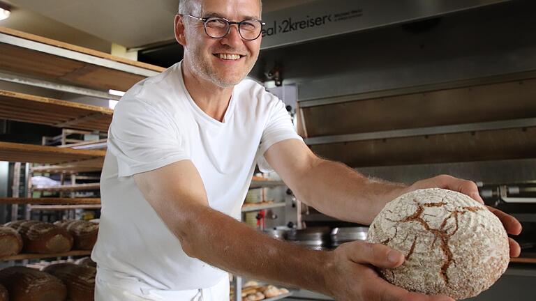 Die Mühe hat sich gelohnt: Hans Gebert aus Gnodstadt mit dem Brot, das mit einer (fast) vergessenen Landweizen-Sorte gebacken wird.&nbsp;