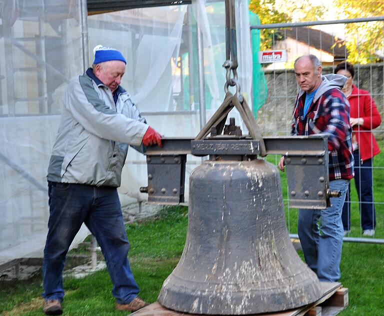 Sicher am Boden angekommen: die Herz-Jesu-Glocke, mit einem Gewicht von 400 Kilogramm und einem Durchmesser von 101 Zentimetern. Robert Back (links) und Adolf Schneider sorgen für die sichere Landung.