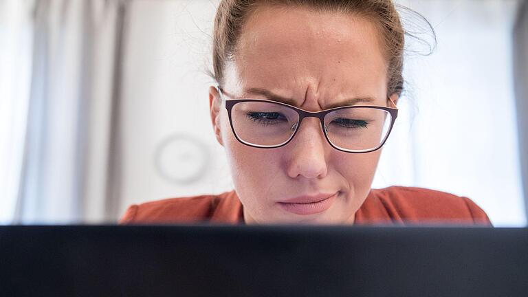 Eine Frau sitzt mit skeptischem Blick am Notebook.jpeg       -  Hier stimmt etwas nicht: Wer Wohngeld beantragen möchte, sollte die Finger von einer bestimmten Website lassen.