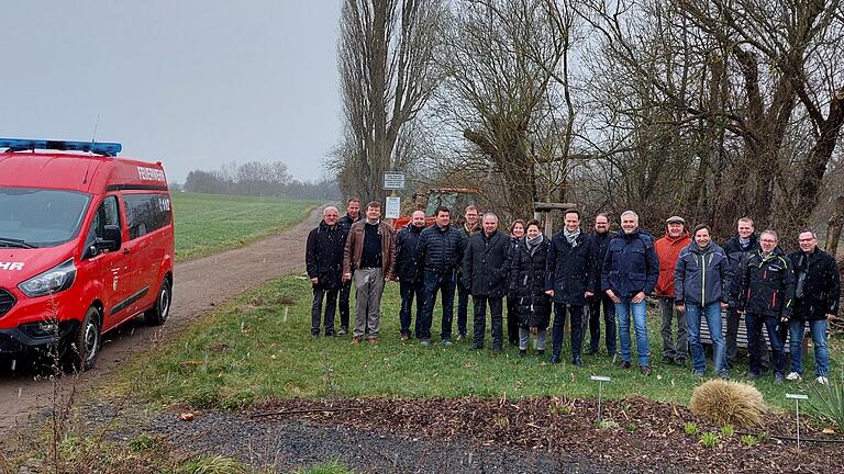 Mitarbeitende der Verwaltungen, lokale Akteure sowie Landrat Florian Töpper und Bürgermeister Thomas Heinrichs freuen sich über den gelungenen Auftakt des Gemeindedialogs in Lülsfeld. Im Hintergrund der Häckselplatz, dessen Nutzung eines der Themen auf der Tagesordnung war.