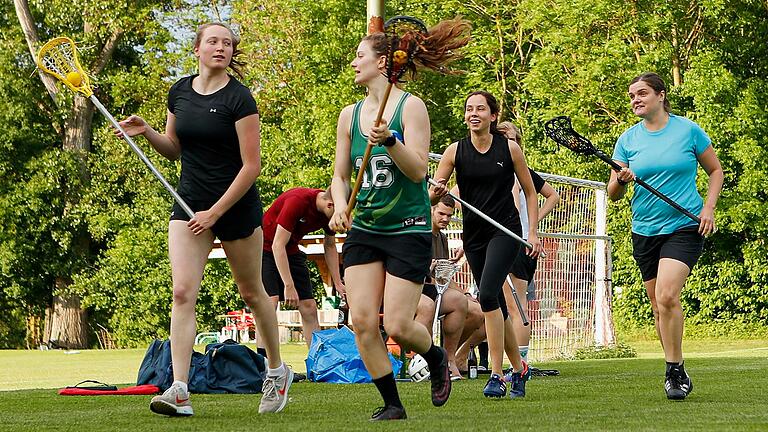 Die Lacrosse-Spielerinnen der FT Würzburg (von links: Charlotte Kielholz, Emily Fuchshuber, Annika Leitenmaier und Eva Gräber) laufen sich auf dem Sportplatz an der Mergentheimer Straße vor dem Training mit Schläger warm. Eine Mannschaft besteht aus neun Spielerinnen und einer Torhüterin. Die Lacrosse-Spielerinnen der FT Würzburg (von links: Charlotte Kielholz, Emily Fuchshuber, Annika Leitenmaier und Eva Gräber) laufen sich auf dem Sportplatz an der Mergentheimer Straße vor dem Training mit Schläger warm. Eine Mannschaft besteht aus neun Spielerinnen und einer Torhüterin.