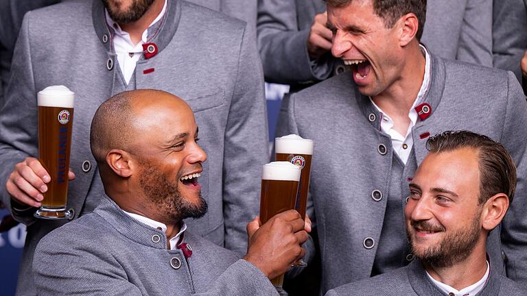 Paulaner Lederhosen-Shooting beim FC Bayern       -  Anstoßen auf den nächsten Sieg? Vincent Kompany (vl) und Thomas Müller (hr) prosten sich zu.