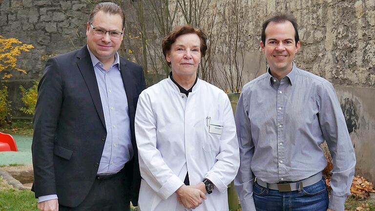 Simon Kuttenkeuler, Vorsitzender des Vereins 'Kinderklinik am Mönchberg e.V.' (von links), Prof. Dr. med. Christina Kohlhauser-Vollmuth, Chefärztin der Missio Kinderklinik, und Bastian Späth, Eikona AG, bei der Spendenübergabe vor der Missio Kinderklinik.