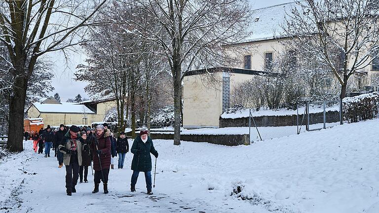Wanderer gehen an der Kirche St. Laurentius von Waldsachsen vorbei. Wanderer gehen an der Kirche St. Laurentius von Waldsachsen vorbei.