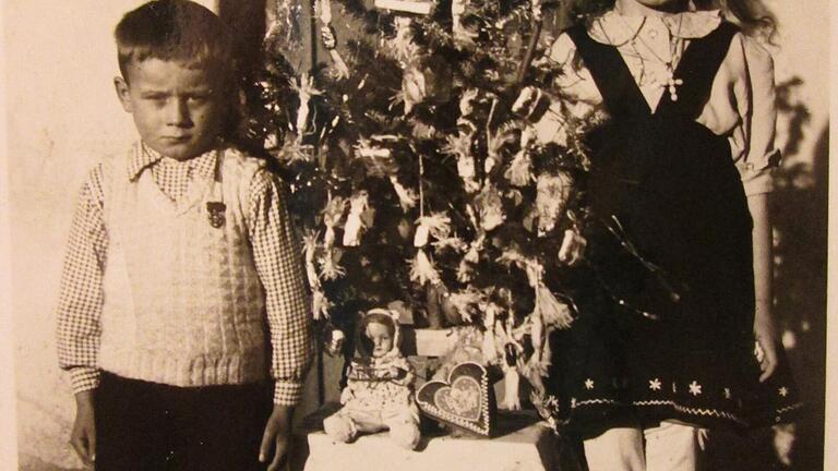 Das Bild zeigt Elisabeth Brenner und Josef Brenner als Kinder neben einem Weihnachtsbaum zu der Zeit, als ihre Familie noch in einer Baracke des ehemaligen Reichsarbeitsdienst-Lagers in der Pestalozzistraße in Gerolzhofen lebten.