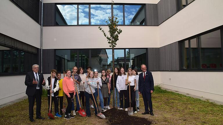 Schüler und Schülerinnen pflanzten eine Winterlinde. Diese soll so wachsen wie die Schule. Landrat Helmut Weiß (links) und Schulleiter Wolfram Schröttel (rechts) freuten sich über den gelungenen Abschluss der Einweihungsfeier.