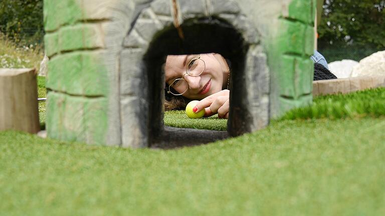 Unsere Reporterin Maria Lisa Schiavone testet den Adventure Golf Parcour in Kitzingen. Hier soll der Golfball durch ein Tor im Miniatur-Falterturm rollen.