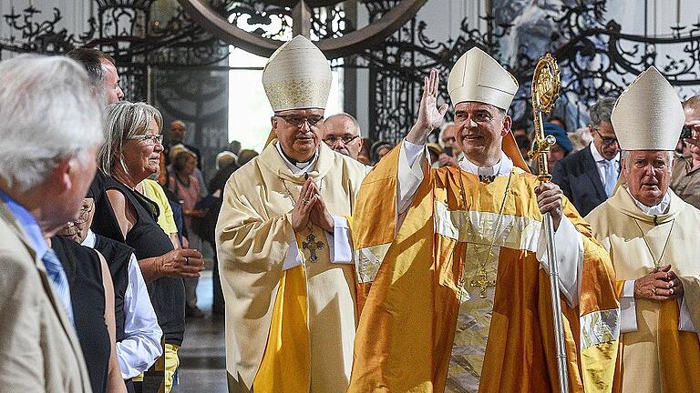 Bischof Franz Jung verlässt nach der Weihe in vollem Ornat den Dom. Rechts sein Vorgänger Friedhelm Hofmann, links xxxxx