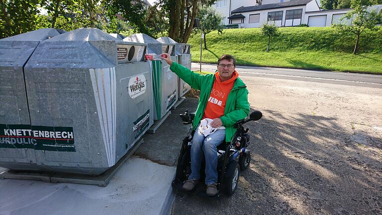 Ursprünglich und wie auf diesem Bild zu sehen, waren die Glascontainer etwas weit von der Kante des Betonsockels entfernt aufgestellt. Rollstuhlfahrer Norbert Sandmann tut sich hier schon schwer, das Einwurfloch zu erreichen. Da wurde inzwischen nachgebessert, die Container stehen näher an der Kante.