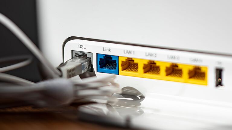 WLAN-Router       -  Ein LAN-Kabel steckt im DSL-Steckplatz eines WLAN-Routers.