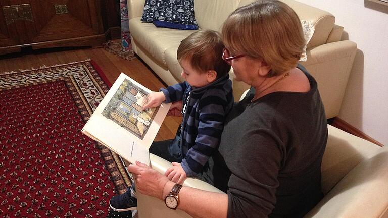 Oma sein ist spitze! Oma Ursula betrachtet mit Enkel Jonas ein Bilderbuch.