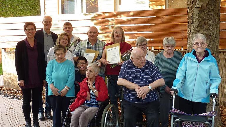 Seit 30 Jahren arbeiten die Eheleute Martina und Harald Kalnischkies (Bildmitte mit Urkunden)im Wohnheim der Lebenshilfe in Bad Kissingen. Bei einer Feierstunde wurden die beiden Pädagogen, die damals die Anfänge des Hauses in der Bad Kissinger Hartmannstraße mitgestaltet haben, für ihren Einsatz und die langjährige Treue zur Lebenshilfe Bad Kissingen geehrt.Im Bild die Bewohner  mit der Aufsichtsratsvorsitzenden Monika Fella (ganz links), Vorstand Alex Iffert (zweiter von links) und Wohnheim...       -  Seit 30 Jahren arbeiten die Eheleute Martina und Harald Kalnischkies (Bildmitte mit Urkunden)im Wohnheim der Lebenshilfe in Bad Kissingen. Bei einer Feierstunde wurden die beiden Pädagogen, die damals die Anfänge des Hauses in der Bad Kissinger Hartmannstraße mitgestaltet haben, für ihren Einsatz und die langjährige Treue zur Lebenshilfe Bad Kissingen geehrt.Im Bild die Bewohner  mit der Aufsichtsratsvorsitzenden Monika Fella (ganz links), Vorstand Alex Iffert (zweiter von links) und Wohnheimleiterin Barbara Karkoszka (vierte von links). Lebenshilfe