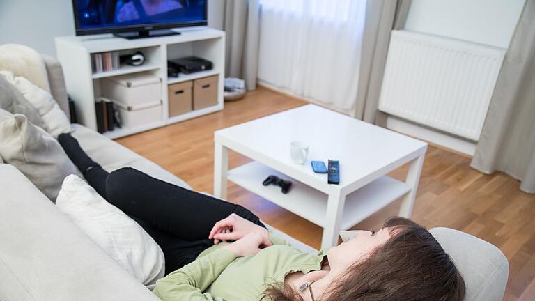 Vor dem Fernseher eindösen.jpeg       -  Weggedöst, aber der Fernseher läuft weiter: Das kann sich negativ auf die Schlafqualität auswirken. Wer ausgeruht aufwachen möchte, kann einiges beachten.