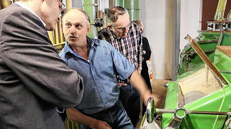 Unterwegs in der Schreckemühle: Inhaber Gerhard Wiesmann (Mitte) erklärt Landrat Thomas Schiebel die Funktion eines Walzenstuhles.