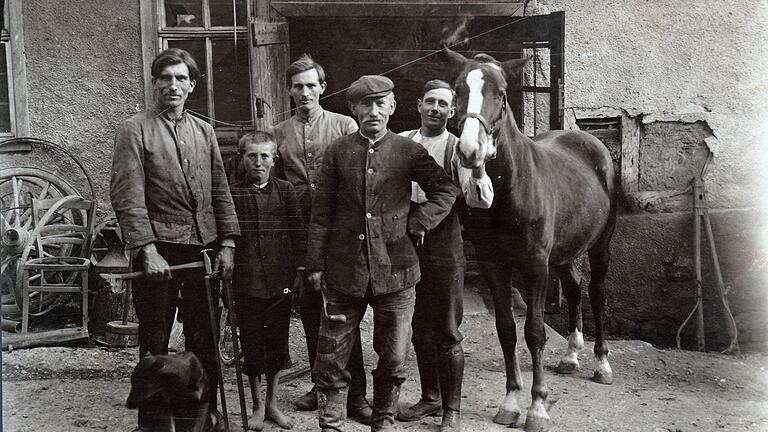 Josef Greßer mit seinen Söhnen Otto, Albert und Viktor vor der Schmiede um 1930. Sie haben wohl soeben das Pferd mit neuen Hufeisen beschlagen.