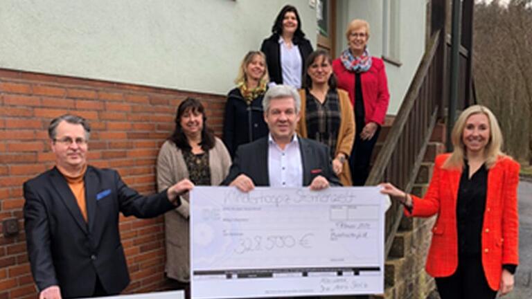 Zusammen mit Frau Staatssekretärin Anna Stolz (vorne rechts) freuen sich Vorsitzender Stefan Zöller (Mitte), stellvertretender Vorsitzender Dr. Thomas Stähler (vorne links) und das gesamte Team vom Kinderhospiz Sternenzelt Mainfranken über die zugesagten Zuschüsse. Zusammen mit Frau Staatssekretärin Anna Stolz (vorne rechts) freuen sich Vorsitzender Stefan Zöller (Mitte), stellvertretender Vorsitzender Dr. Thomas Stähler (vorne links) und das gesamte Team vom Kinderhospiz Sternenzelt Mainfranken über die zugesagten Zuschüsse.