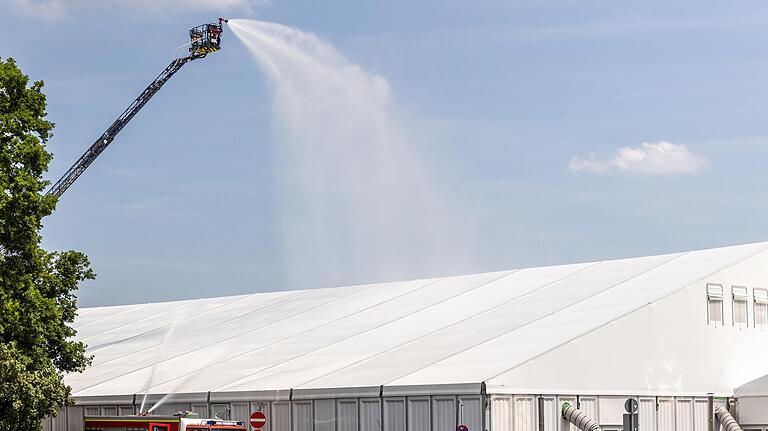 Unter Einsatz einer Drehleiter beregnete die Feuerwehr am Samstag das Zeltdach des Impfzentrums, um die Temperatur drinnen zu senken. Unter Einsatz einer Drehleiter beregnete die Feuerwehr am Samstag das Zeltdach des Impfzentrums, um die Temperatur drinnen zu senken. 