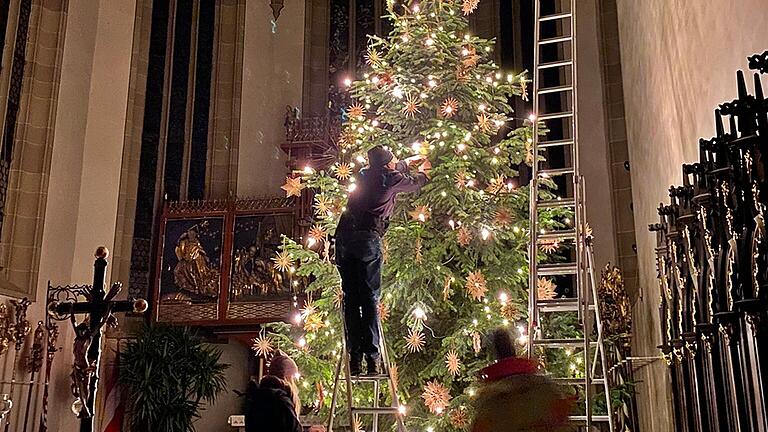 Die Lichterketten werden angebracht, so dass der Christbaum an Heiligabend gut beleuchtet ist. Geschmückt wurde er mit vielen Strohsternen.