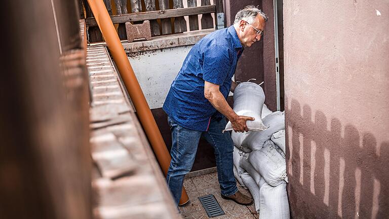 Günter Wirth sichert sein Elternhaus in Westheim mit Sandsäcken (Archivbild). 1,60 Meter hoch stand das Wasser im Juli 2021 im Keller. Eine Interessengemeinschaft will nun den Hochwasserschutz verbessern.