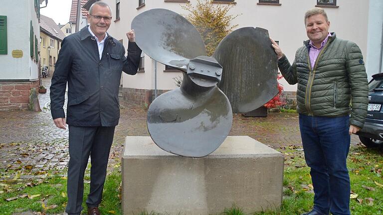 Bürgermeister Thomas Stamm (links im Bild) und BVG-THG-Geschäftsführer Christian Hochbein freuen sich über die neu renovierte Schiffsschraube am Mainkai von Marktheidenfeld.